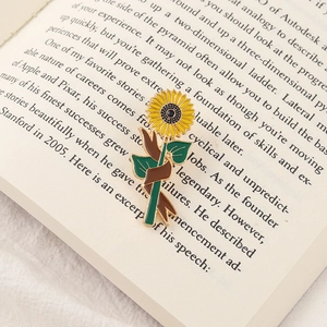Cartoon sunflower enamel pin with yellow petals on an open book for graduation gift