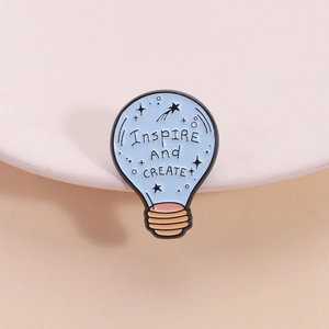 Spilla smaltata a forma di lampadina azzurra con slogan Inspire And Create stellato