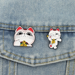 Lot de pins émaillés chat porte-bonheur Maneki Neko blanc sur une veste en jean