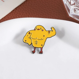Détail d'un badge poussin musclé en émail sur une surface en céramique blanche