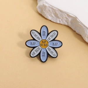 Detail of blue daisy enamel pin with fun text like NAP OR NOT on petals