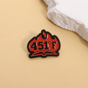 Détail de la broche livre Fahrenheit 451 avec flamme en émail rouge et texte 451 F