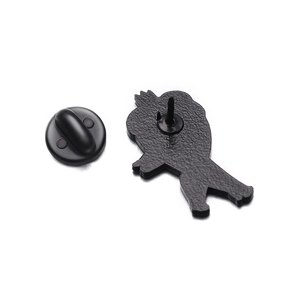 Macro view of cartoon tooth brooch back showing black clutch pin and textured metal finish