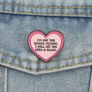 Pink heart enamel pin with funny quote pinned on denim jacket pocket for accessories