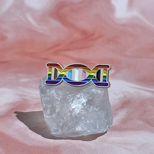 Detailed view of rainbow DNA enamel pin featuring Pride theme on white crystal base