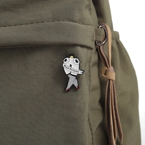 Macro shot of Miss Fresno cartoon pin with crown and fishnet stockings on an olive bag