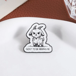Épingle émaillée chèvre rigolote avec texte humoristique sur une assiette blanche