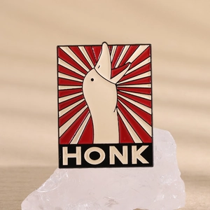 Detail of white goose enamel pin with HONK text on a starburst background