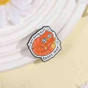 Close-up of orange cat enamel pin with sensitive quote on white daisy background