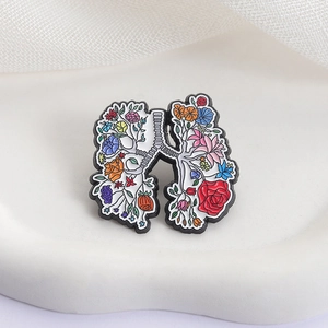 Creative lung shape floral enamel pin with colorful roses on a white marble background