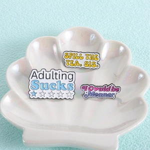 Funny enamel pins set with text like Spill the Tea and Adulting Sucks for backpacks