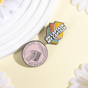 Detailansicht der literarischen Emaille-Pins mit Schreibmaschinen- und Buchstapel-Motiv