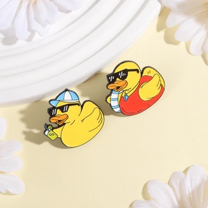 Detailed macro shot of summer themed cartoon yellow duck enamel pins with sunglasses