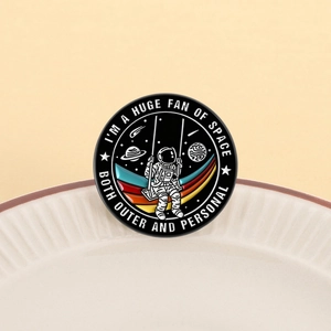 Emaille-Weltraum-Anstecknadel mit Astronauten-Motiv und Spruch auf weißem Teller