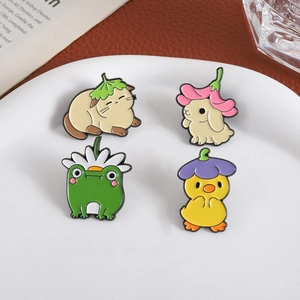 Detail view of four colorful enamel animal pins on a clean white porcelain tray