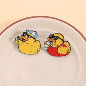 Detailaufnahme der Cartoon-Emaille-Pins mit gelben Enten, Sonnenbrille und Sommer-Accessoires