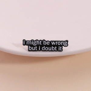 Emaille-Anstecknadel mit dem Spruch 'I might be wrong' auf einem Keramiktablett
