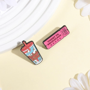 Pink Ticket to Delululand and Delulu Juice enamel pin set on a pale yellow background