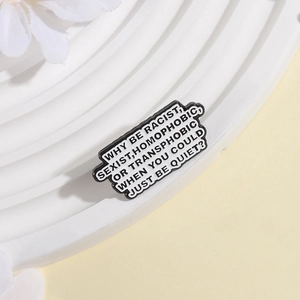 Enamel lapel pin with anti-discrimination typography on a white display stand