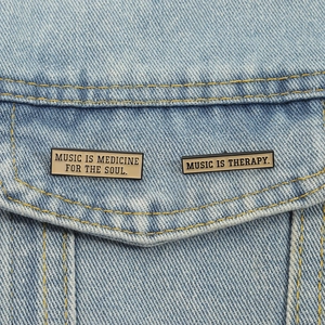 Enamel music pins set on denim jacket with Music Is Medicine For The Soul text