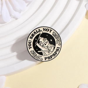 Detail of round enamel cat pin with magic wand and You Shall Not Pspspsps lettering
