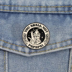 Creative knight cat enamel pin with funny wizard text on a blue denim jacket pocket