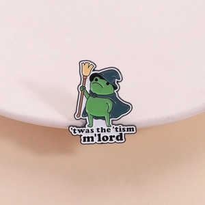 Detail der Frosch-Zauberer-Emaille-Nadel mit Spruch und blauem Umhang auf Stativ