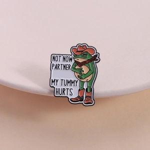 Funny green frog enamel pin wearing cowboy hat with Not Now Partner My Tummy Hurts text