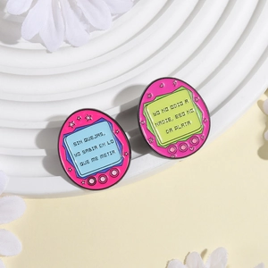 Retro Spanish electronic pet enamel pins in pink on a decorative display stand