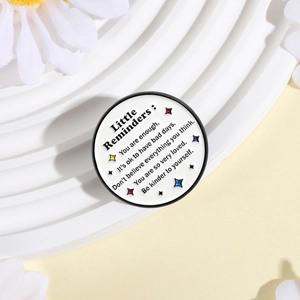 Detail of round enamel badge with inspirational quotes on a white textured display