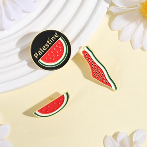 Detail of three enamel watermelon pins on a stand featuring a map and Palestine text