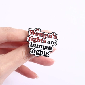Detail of enamel pin with Women's rights are human rights slogan on metal backing