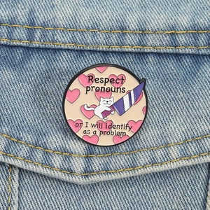 Funny white cat holding a knife enamel pin with Respect Pronouns message on denim jacket