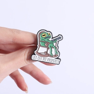 Detailansicht der lustigen Frosch-Emaille-Anstecknadel mit GET OFF MY PROPERTY Text