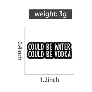 Dettaglio di una spilla bianca e nera con testo could be water could be vodka