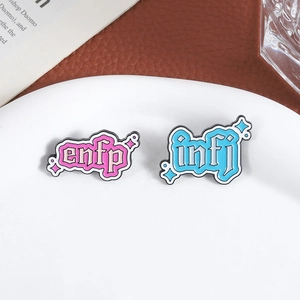 MBTI enamel pins featuring pink ENFP and blue INFJ designs with retro lettering