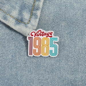 Vintage 1985 colorful enamel brooch pin on denim jacket for retro fashion look