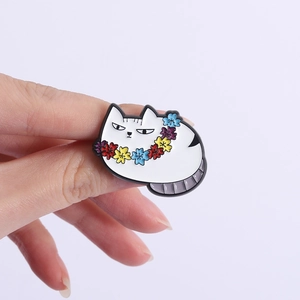Detailed view of white cartoon cat enamel pin with floral collar accessory
