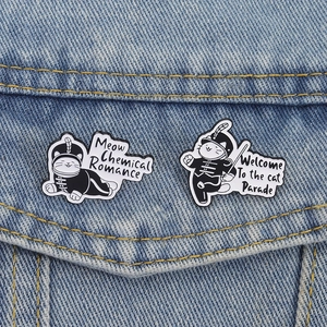 Cat parade enamel pins set in black and white on a denim jacket pocket
