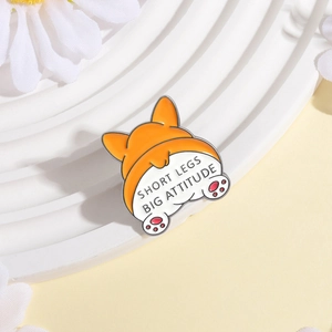 Détail de l'épingle en émail Corgi avec le texte Short Legs Big Attitude sur marches blanches