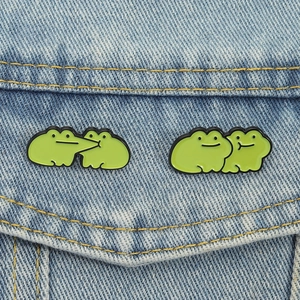 Cute green frog enamel pin set on blue denim jacket pocket for a funny best friend gift