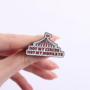 Detail of enamel circus tent pin with 'NOT MY CIRCUS NOT MY MONKEYS' text slogan