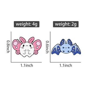 Macro view of blue and pink cartoon animal enamel pins showing precise size and weight details