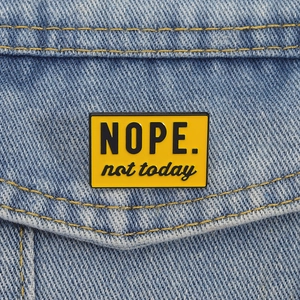 Creative yellow NOPE not today enamel pin badge on blue denim jacket accessory