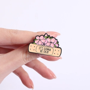 Rosa Kirschblüten-Emaille-Anstecknadel mit Band-Aid-Form und It's Gonna Be Okay-Slogan