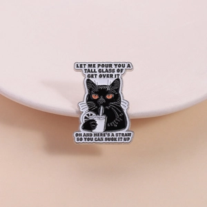 Close-up of black cat enamel pin with funny quote and polished metal finish on white dish