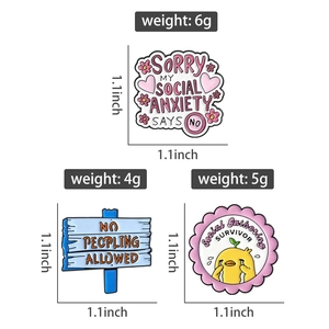 Detailed view of enamel pins showing social anxiety text and dimensions of 1.1 inches