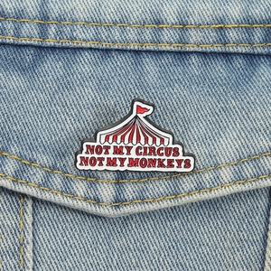 Detail of Circus Tent Enamel Pin with Not My Circus Not My Monkeys quote on denim jacket