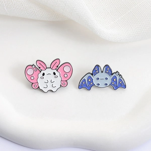 Cute moth and bat enamel pin set featuring a starry blue wing design on a white background