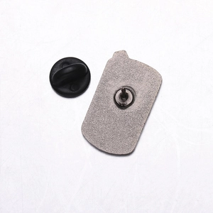 Macro shot of silver zinc alloy brooch back featuring a sharp pin and black rubber clutch